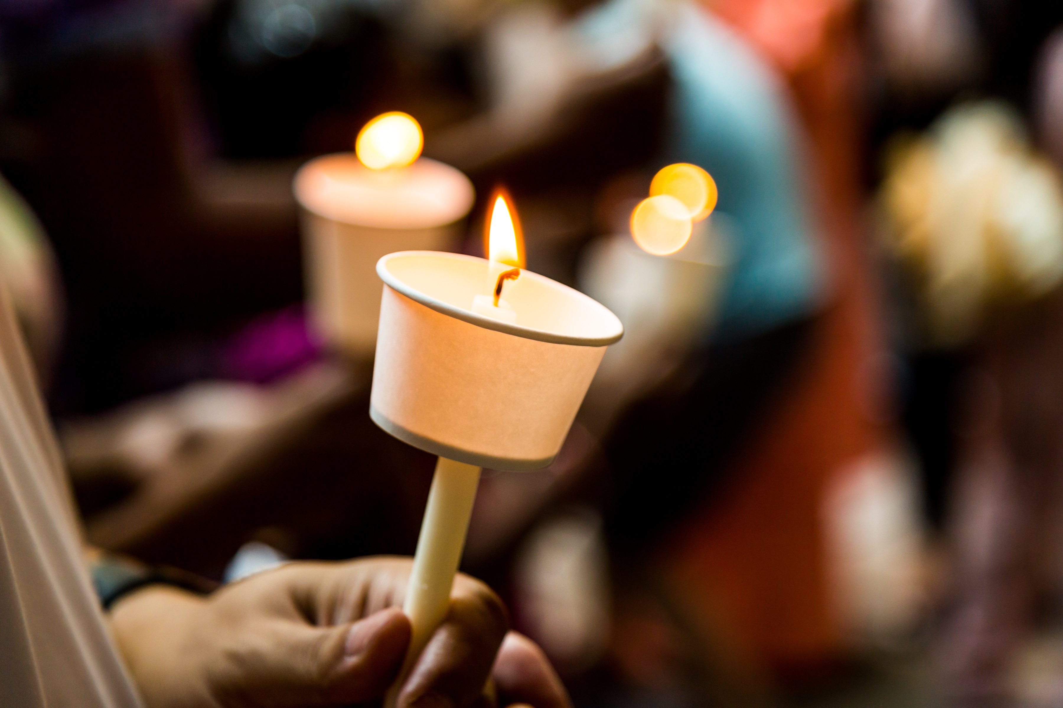 person holding a candle in remembrance