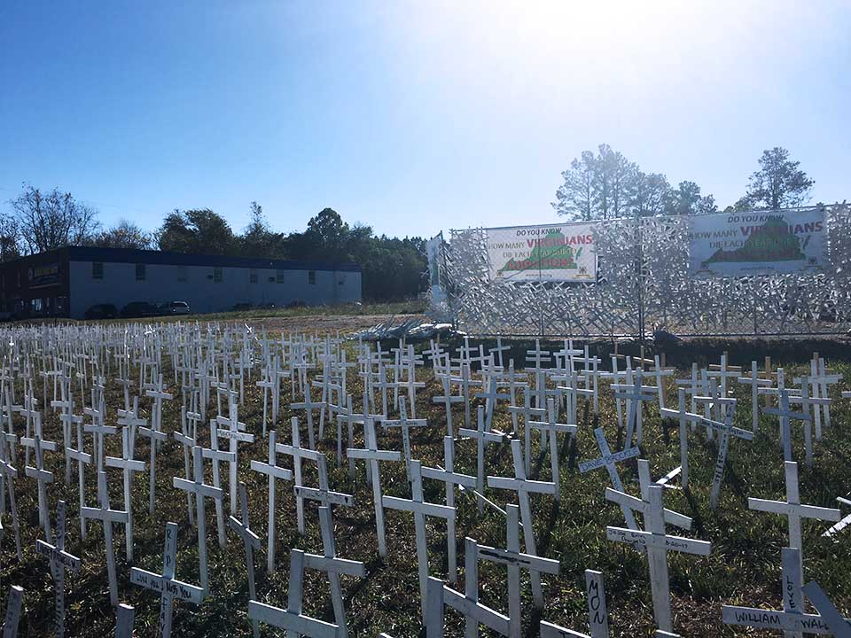 white crosses in ground sunny day building in the background